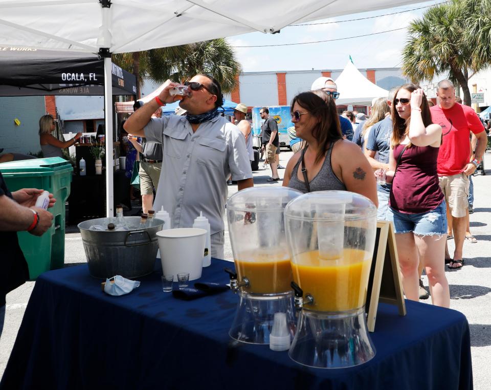 Guests enjoy drinks as they stroll among booths at a past edition of the DeLand Craft Beer Festival. The event returns on Saturday, along Georgia Avenue in downtown DeLand.