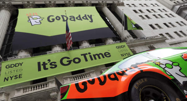 GoDaddy signage and Danica Patrick's race car announce the company's IPO, in front of the New York Stock Exchange, Wednesday, April 1, 2015. (AP Photo/Richard Drew)