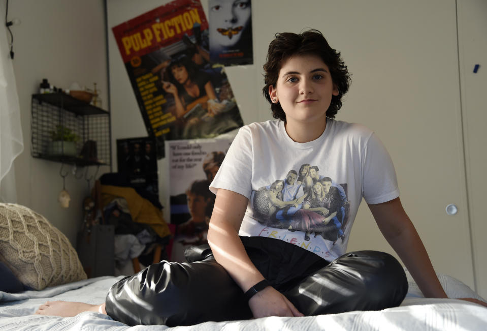In this Thursday, Aug. 22, 2019 photo, Esme Goldman, 13, wears a "Friends" t-shirt as she poses for a portrait in her bedroom, in Pasadena, Calif. “Friends” marks its 25th anniversary Sunday, Sept. 22 and the quintessential 1990s sitcom has attracted a new slew of viewers who are barely half that age. Tween and teen girls in particular have embraced the show with huge enthusiasm, taking a show that belonged to Generation X and making it their own. (Photo by Chris Pizzello/Invision/AP)