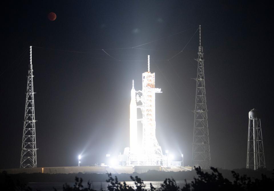 The Moon is seen during a total lunar eclipse above NASAs Space Launch System (SLS) rocket with the Orion spacecraft aboard atop a mobile launcher, illuminated by spotlights, at Launch Pad 39B at NASAs Kennedy Space Center on Tuesday, November 8, 2022 in Cape Canaveral, Florida. NASAs Artemis I flight test is the first integrated test of the agency's deep space exploration systems: the Orion spacecraft, SLS rocket, and supporting ground systems. Launch of the uncrewed flight test is targeted for Nov. 14 at 12:07 a.m. EST.