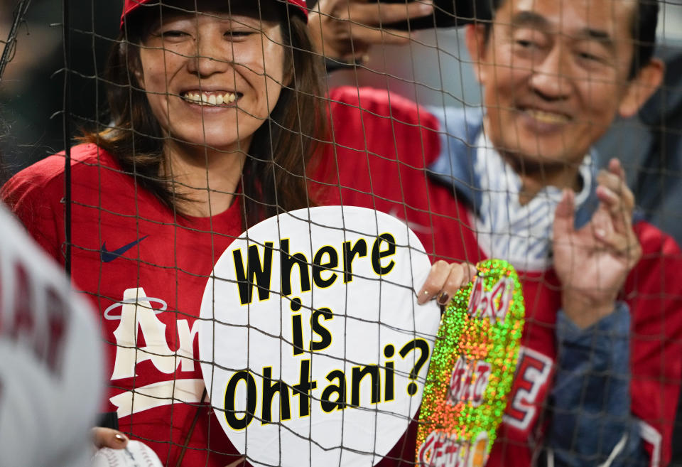 A fan wearing a Los Angeles Angels shirt holds a sign reading "Where is Ohtani?," as Los Angeles Angels' Shohei Ohtani was not in the starting lineup against the Seattle Mariners, before a baseball game Tuesday, Sept. 12, 2023, in Seattle. (AP Photo/Lindsey Wasson)