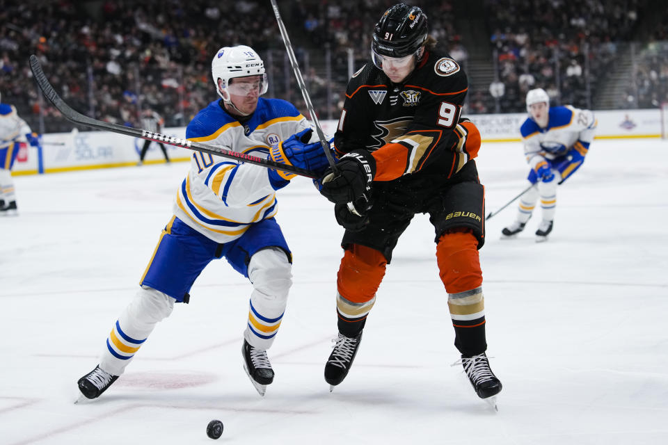 Buffalo Sabres defenseman Henri Jokiharju, left, and Anaheim Ducks center Leo Carlsson vie for the puck during the first period of an NHL hockey game Tuesday, Jan. 23, 2024, in Anaheim, Calif. (AP Photo/Ryan Sun)