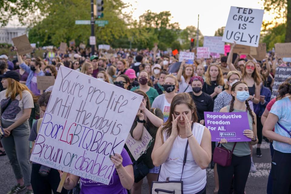 A largely female crowd, one with a sign reading: "You're 'pro-life' until the baby is poor, LGBTQ, Black, brown or disabled."