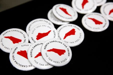 North Carolina campaign buttons sit on a table before the start of a rally with Republican U.S. presidential nominee Donald Trump in Fletcher, North Carolina, U.S. October 21, 2016. REUTERS/Jonathan Ernst - RTX2PW7X