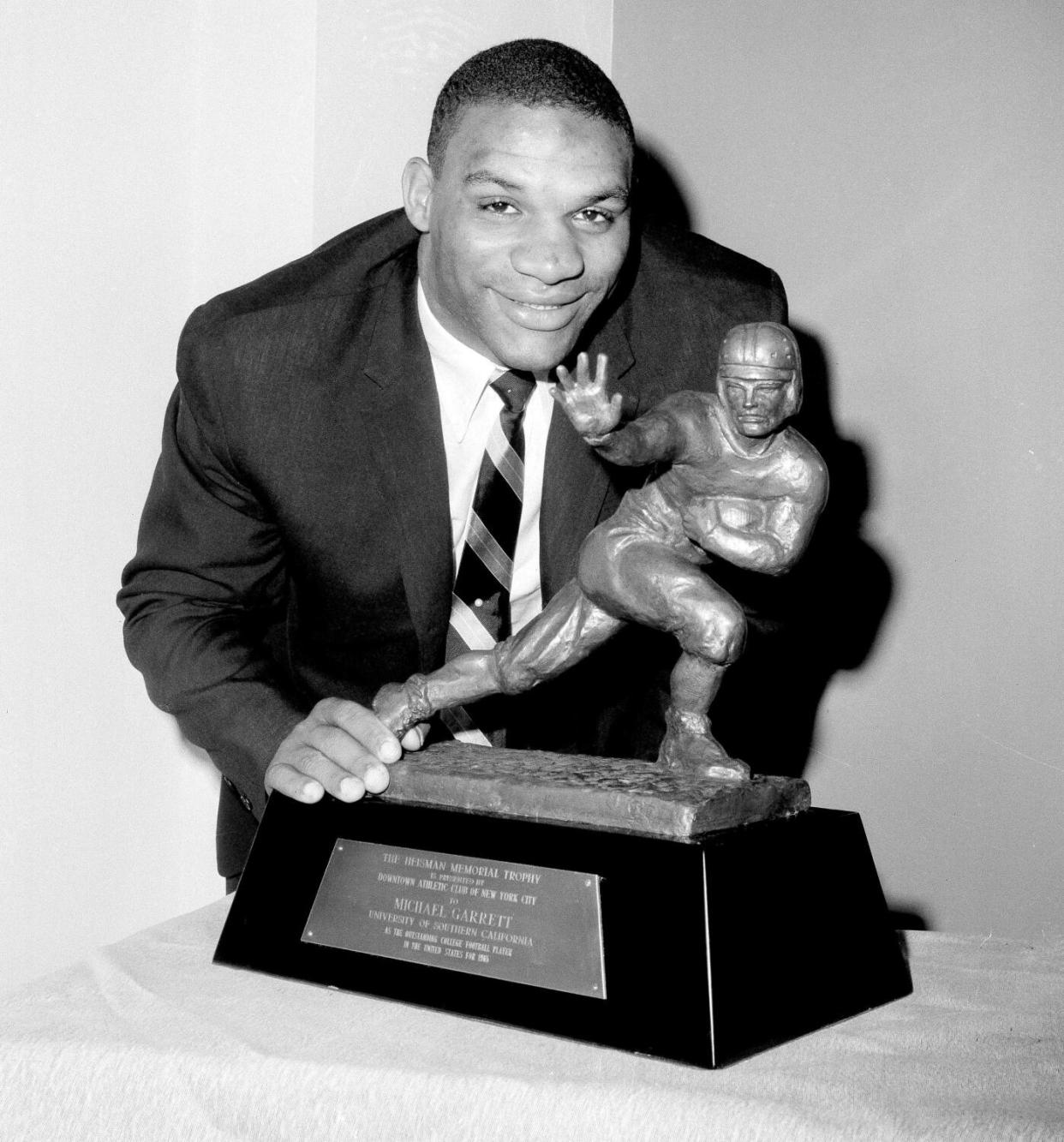 USC's halfback Mike Garrett, winner of the 1965 Heisman trophy holds the trophy