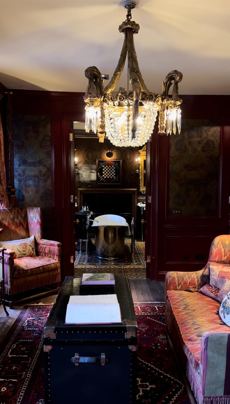 An overview of a sitting room with a silver bathtub in the distace