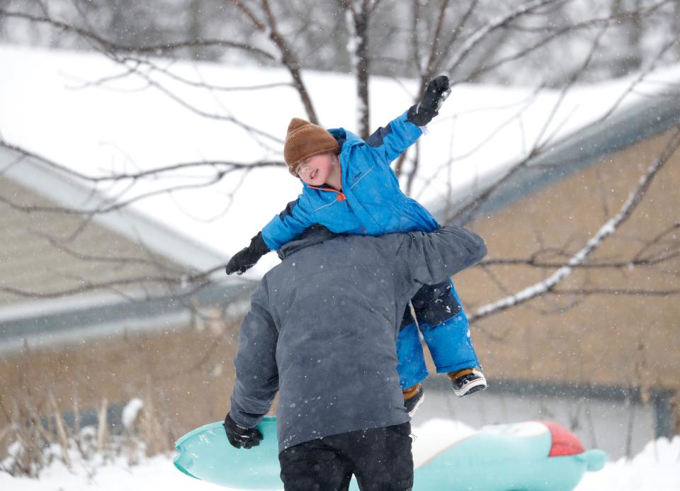 Tate R. Rathsack, 3, of Winchester enjoys getting a lift up a sledding hill from his father, Joe Rathsack, during a snowstorm Tuesday at Fritse Park in Neenah.