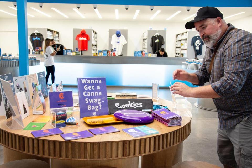 Brian Applegarth, CEO of Cultivar Strategies, arranges a display about the new MoTown CannaPass program from Visit Modesto inside Cookies dispensary July 27, 2021 in Modesto, Calif.