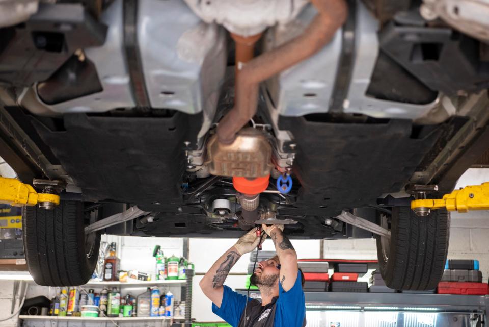 Joseph Avola etches a license plate number on a catalytic converter at Doyle's Automotive on Saturday, Aug. 27, 2022. 
Doyle's Automotive is working with the New Milford Police Department in an effort to prevent catalytic converter theft by painting the converter with a high temperature paint and etching the license plate number of the vehicle into the converter. The service is free to New Milford residents from 8:30 a.m. to noon on Saturday, Aug. 27, 2022.