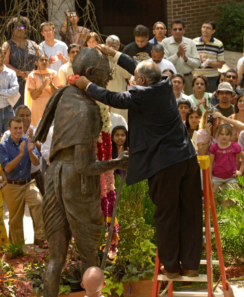 Ashok Bazaz, president of the Gandhi Memorial Society, places a flower garland around an 8-foot tall bronze statue of Mahatma Gandhi after it was unveiled during Gandhi Day at the University of North Florida on Oct. 1, 2006, in Jacksonville.