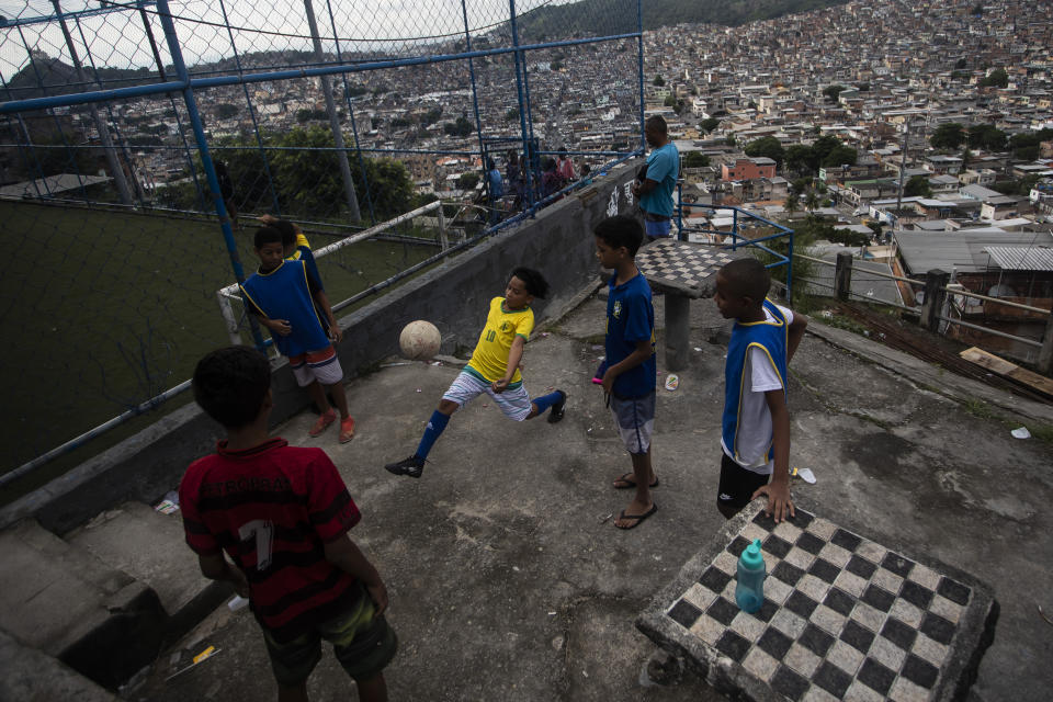 FILE - Youths play soccer as they wait for a street soccer training program run by the Street Child United Brazil non-governmental organization, at the Complexo da Penha favela, in Rio de Janeiro, Brazil, April 29, 2023. After decades of delay and pressure, Brazil announced on Jan. 23, 204 that it will henceforth use “favelas and urban communities” to categorize thousands of poor, urban neighborhoods, instead of the previous term “subnormal agglomerates” that was widely viewed as stigmatizing. (AP Photo/Bruna Prado, File)