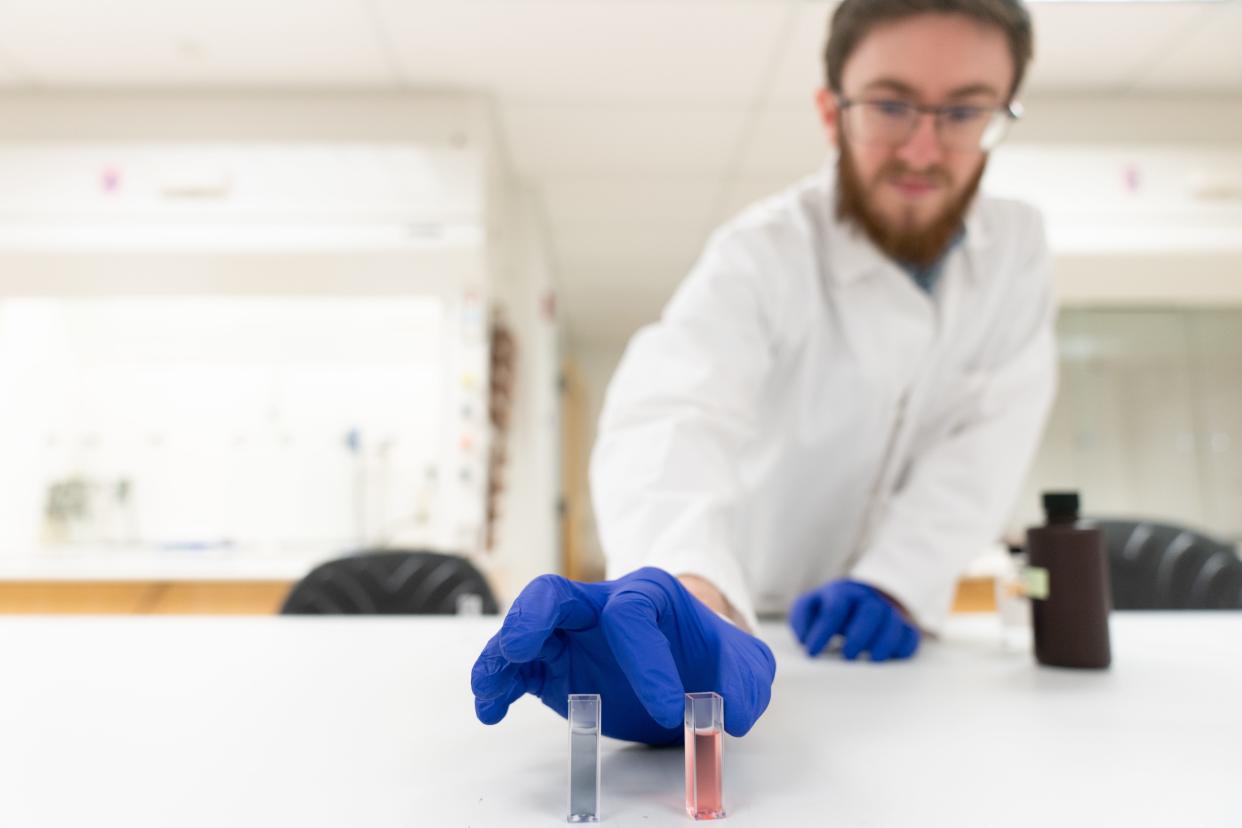 Washburn University senior Ethan Connors searches for such contaminants as lead in drinking water Thursday afternoon in a lab at Stauffer Hall. Connors' research found that gold nanoparticles suspended in water and acid react to the presence of lead changing the substance to red.