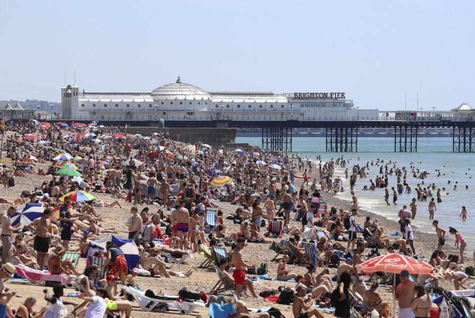 Crowds gather as hot weather draws crowds to the beach in Brighton, England, Thursday June 25, 2020. Coronavirus lockdown restrictions are being relaxed but people should still respect the distancing requirements between family groups. According to weather forecasters this could be the UK's hottest day of the year, so far, with scorching temperatures forecast to rise even further. (Gareth Fuller/PA via AP)