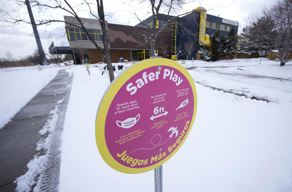 A sign outside the Children's Museum of Denver outlining COVID safety measures reads Safer play and advises people to wear a mask and stay 6 feet apart.