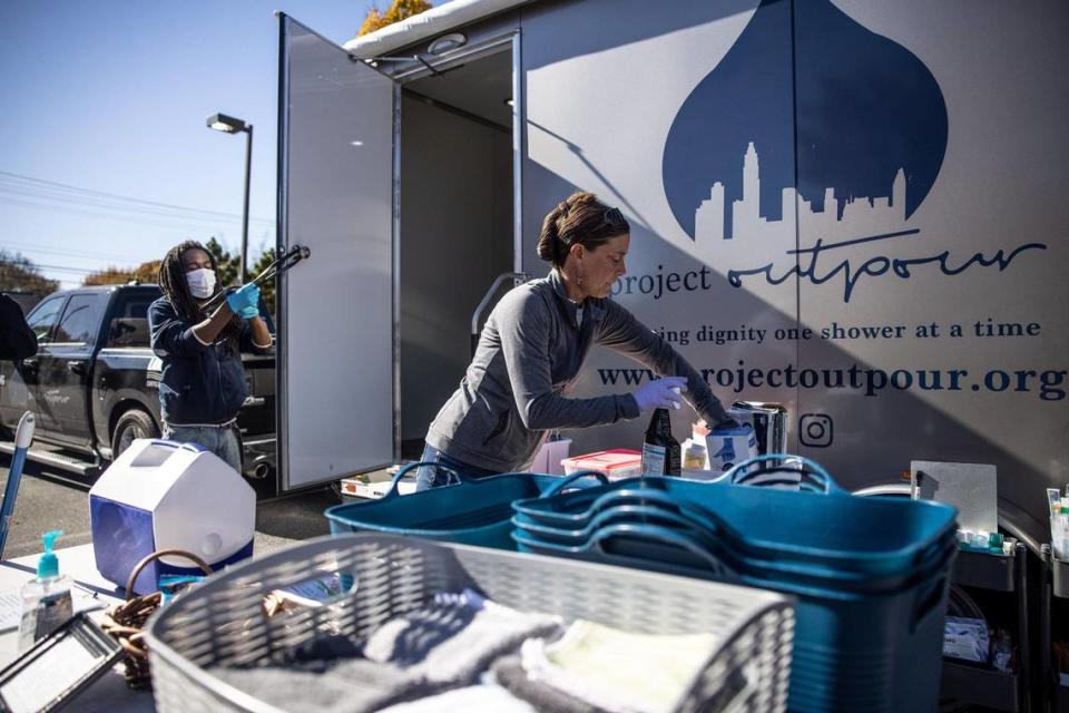 Laura Gorecki cleans up after a guest at Project Outpour outside Hickory Grove Library in Charlotte, on Nov. 21, 2021.