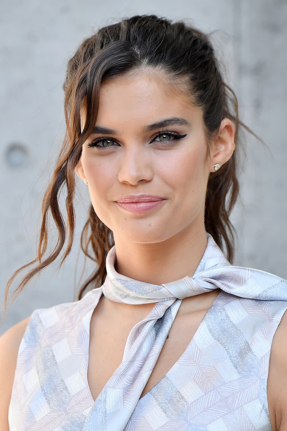 <p>Proving that a ponytail can be practical <em>and </em>pretty, Sara Sampaio added dishevelled waves to the lengths of her hair before securing the style and left a section of wavy tendrils out at the front. Use T3's <a rel="nofollow noopener" href="https://www.net-a-porter.com/gb/en/product/665403?cm_mmc=Google-ProductSearch-UK--c-_-NAP_EN_UK_PLA-_-NAP%C2%A0-%C2%A0UK%C2%A0-%C2%A0GS%C2%A0-+Designer+-+Class_Beauty+-+Type_Haircare%C2%A0-%C2%A0High%C2%A0-%C2%A0BT--Haircare+-+Dryers+%26+Irons_INTL&gclid=Cj0KCQjwlqLdBRCKARIsAPxTGaWrc7JKdjMNKZir66vHZykHn3Aa0EgyywQuysU0RY7jSOqMSIdUwaYaAsDlEALw_wcB&gclsrc=aw.ds" target="_blank" data-ylk="slk:Tousled Waves Styler;elm:context_link;itc:0;sec:content-canvas" class="link ">Tousled Waves Styler</a> alongside lots of Bumble and bumble's <a rel="nofollow noopener" href="https://www.bumbleandbumble.co.uk/product/19061/221/style/texture-sprays/surf-spray?gclid=Cj0KCQjwlqLdBRCKARIsAPxTGaWKOcK1HYLeRK_yloXDzVtzusp5CljcthZ1VQyyqnmzbr86EoTw7AgaAsRkEALw_wcB&gclsrc=aw.ds&dclid=CPyp9oHE090CFc4UGwodFH4Arw" target="_blank" data-ylk="slk:Surf Spray;elm:context_link;itc:0;sec:content-canvas" class="link ">Surf Spray</a> to create your messy waves, and accessorise with a Kitsch <a rel="nofollow noopener" href="https://mykitsch.com/basics-hair-ties/" target="_blank" data-ylk="slk:Hair Tie;elm:context_link;itc:0;sec:content-canvas" class="link ">Hair Tie</a> which won't damage your tresses.<br></p>