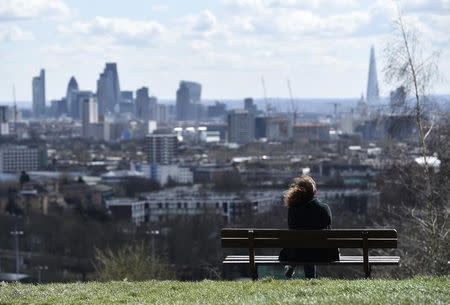 A woman looks towards the City of London financial district from Parliament Hill in north London March 31, 2015. REUTERS/Toby Melville