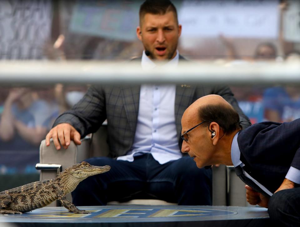 SEC Nation host Paul Finebaum stares down a live alligator on the set during the filming of the SEC Nation college football show, at the Plaza of the Americas on the University of Florida campus, in Gainesville, Fla. Sept. 18, 2021.