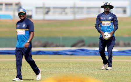 Sri Lanka v India - Sri Lanka Team Practice Session - Galle, Sri Lanka - July 25, 2017 - Sri Lanka's former captain Angelo Mathews looks on as newly appointed Test cricket captain Rangana Herath walks ahead of their first test match. REUTERS/Dinuka Liyanawatte