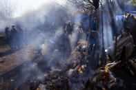 Smoke wafts over a campfire as Mapuche community members keep an eye on lambs roasting over an open fire during celebrations of We Tripantu, the Mapuche new year, in the Corayen community of Los Rios, southern Chile, on Tuesday, June 21, 2022. (AP Photo/Rodrigo Abd)