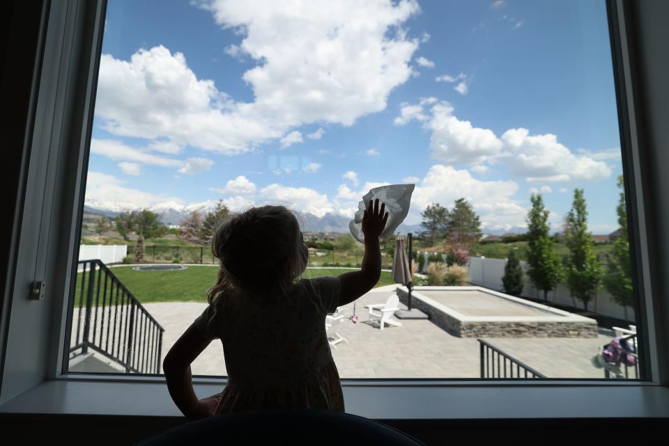 Ruby Evanson, 5, cleans windows at home in Lehi on Thursday, May 18, 2023. | Jeffrey D. Allred, Deseret News
