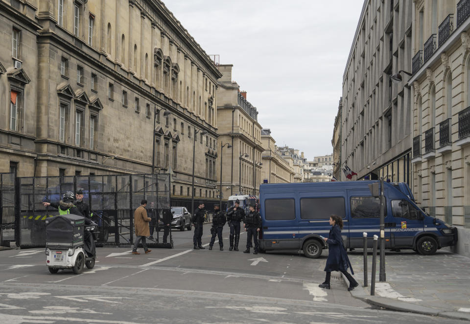 Police officers block the street leading to the National Assembly in Paris, Monday, March 20, 2023. France's government is fighting for its survival Monday against no-confidence motions filed by lawmakers who are furious that President Emmanuel Macron used special constitutional powers to force through an unpopular bill raising the retirement age from 62 to 64 without giving them a vote. (AP Photo/Lewis Joly)