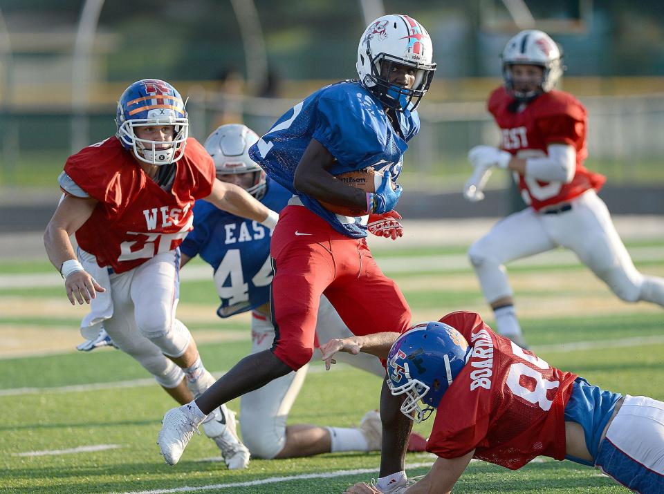 East's Khyree Woody of McKinley spins into the end zone during the first half of the 30th annual Repository East-West All-Star Football Game at GlenOak, July 20, 2019.