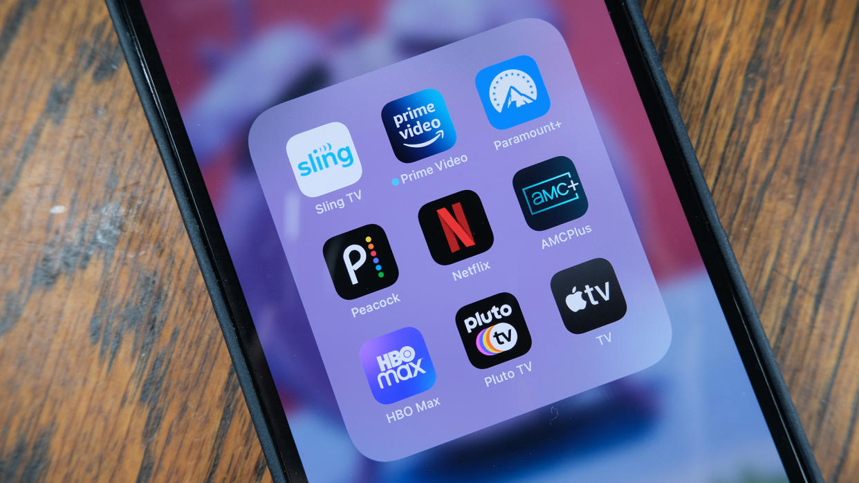  A grid of streaming service apps (Sling, Prime Video, Paramount Plus, Peacock, Netflix, AMC Plus, HBO Max, Pluto TV, Apple TV) open on a phone. 