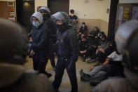 Rap singer Pablo Hasél, background, is surrounded by his supporters as police officers arrest one of the activists at the University of Lleida, Spain, Tuesday, Feb. 16, 2021. A rapper in Spain and dozens of his supporters have locked themselves inside a university building in the artist's latest attempt to avoid a prison sentence for insulting the monarchy and praising terrorism. (AP Photo/Joan Mateu)