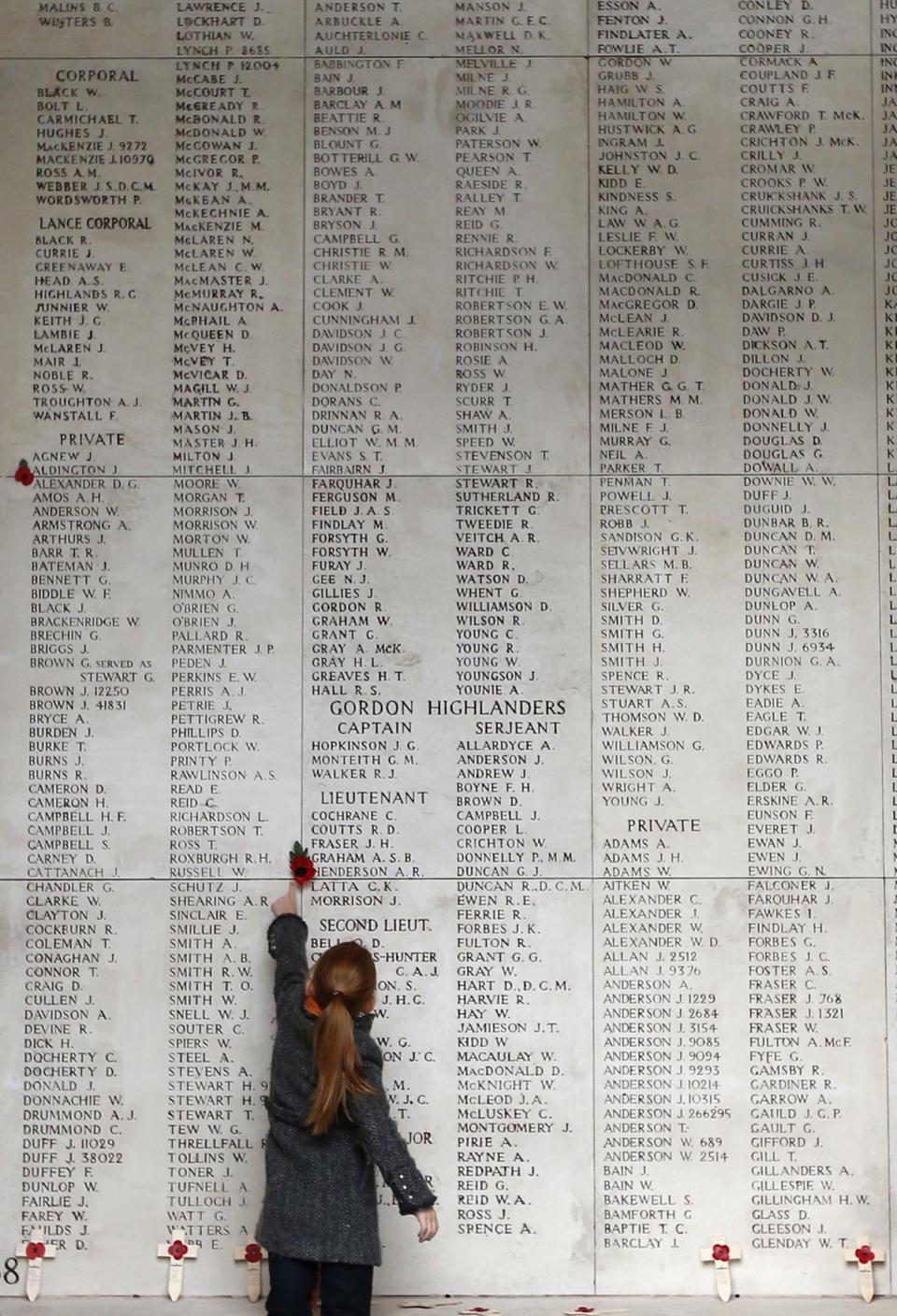 A girl looks at names of Commonwealth soldiers who died in World War One at the Menin Gate Memorial in Ypres