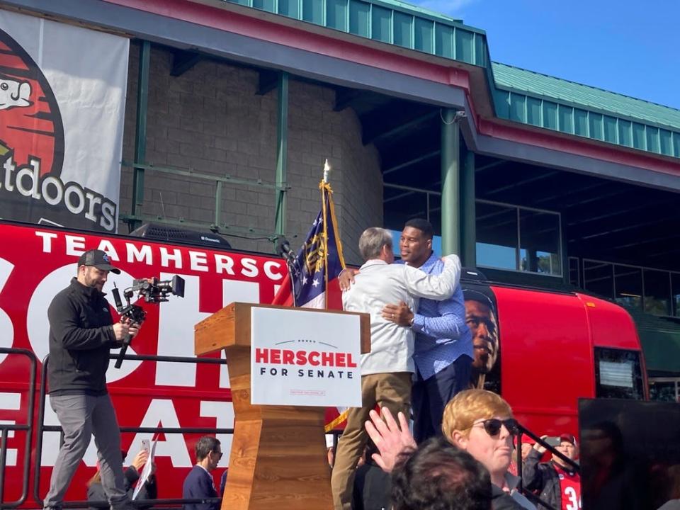 Georgia Gov. Brian Kemp campaigns alongside Senate candidate Herschel Walker on Nov. 19, 2022, in Smyrna.