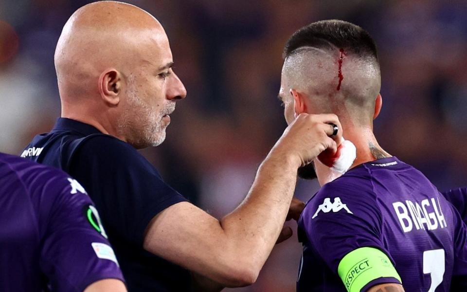  Cristiano Biraghi of Fiorentina receives treatment for a head wound after being struck by an object thrown - Chris Brunskill/Fantasista/Getty Images