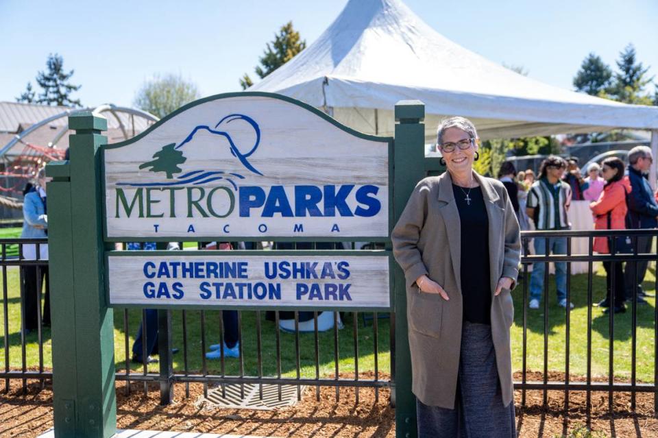 Council member Catherine Ushka poses next to the sign at a park renamed for her last month.