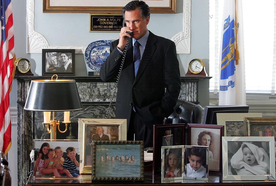 FILE - In this June 23, 2005, file photo, then-Massachusetts Gov. Mitt Romney talks on the phone in his office at the Statehouse in Boston. What worked in the corporate boardroom for Mitt Romney didn't fly in the more raucous corridors of the Massachusetts Legislature. The Republican took over as governor in 2003 after a long, successful career as CEO at private equity firm Bain Capital, where it was pretty much Romney's way or the highway. (AP Photo/Chitose Suzuki, File)