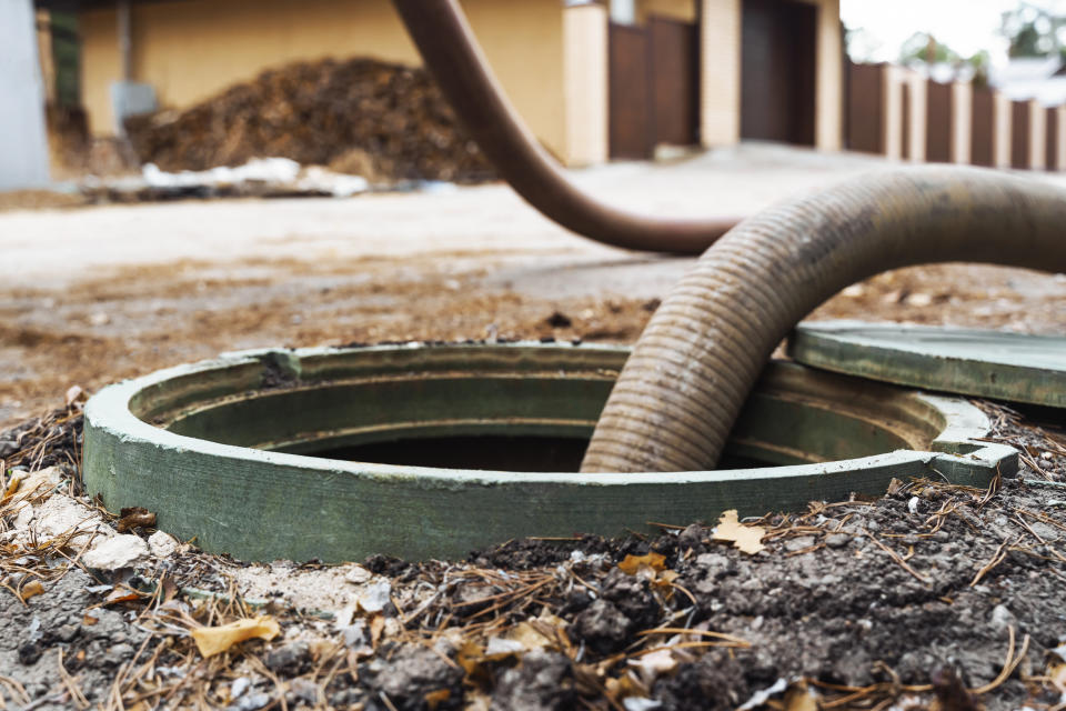 Large hose inserted into a septic tank for draining