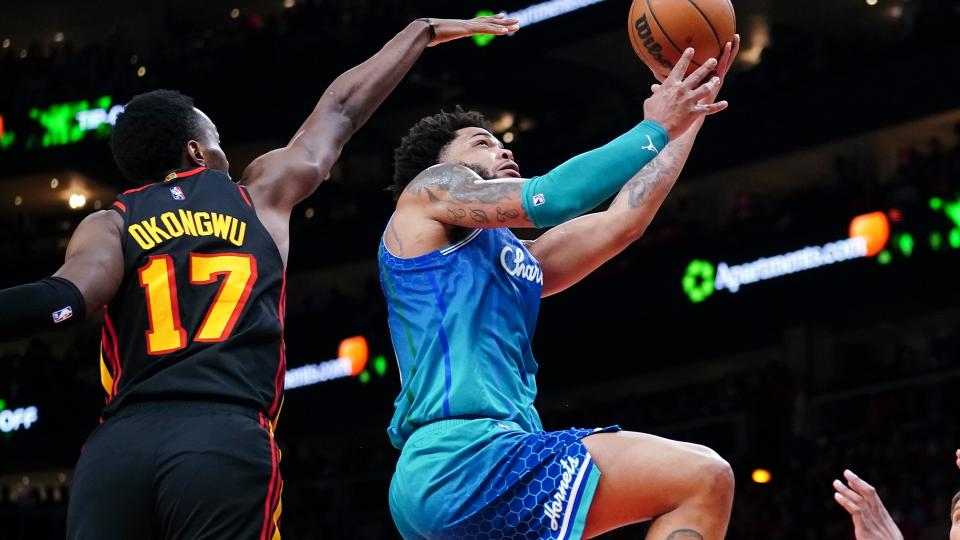 Charlotte Hornets forward Miles Bridges (0) drives past Atlanta Hawks forward Onyeka Okongwu (17) during the second half of an NBA play-in basketball game Wednesday, April 13, 2022, in Atlanta.