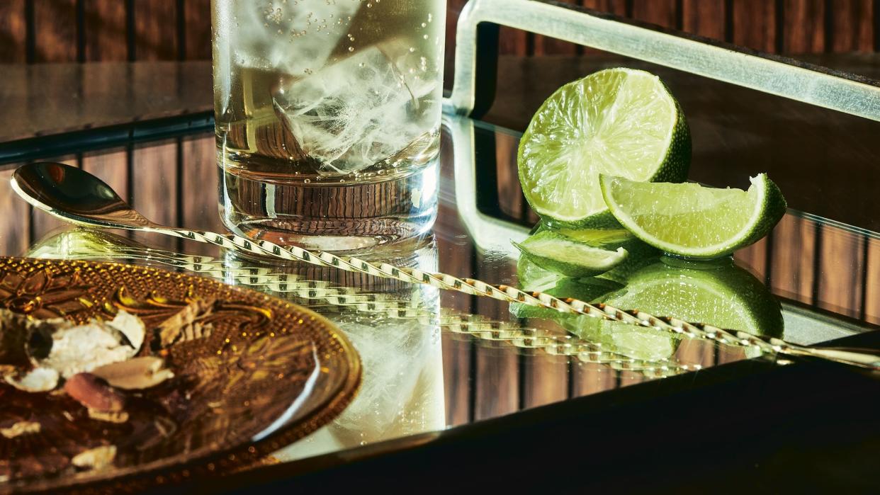 a glass of liquid with a slice of lime on a table