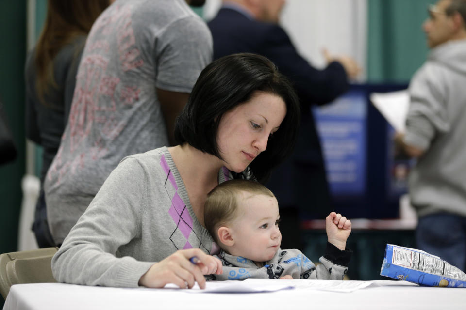 In this April 22, 2014 photo, Sarah Keegan of Windham, N.Y., with her son Kevin, fills out paperwork during a job fair at Columbia-Greene Community College in Hudson, N.Y. The Labor Department on Friday, May 2, 2014 said U.S. employers added a robust 288,000 jobs in April, the most in two years, the strongest evidence to date that the economy is picking up after a brutal winter slowed growth. (AP Photo/Mike Groll)