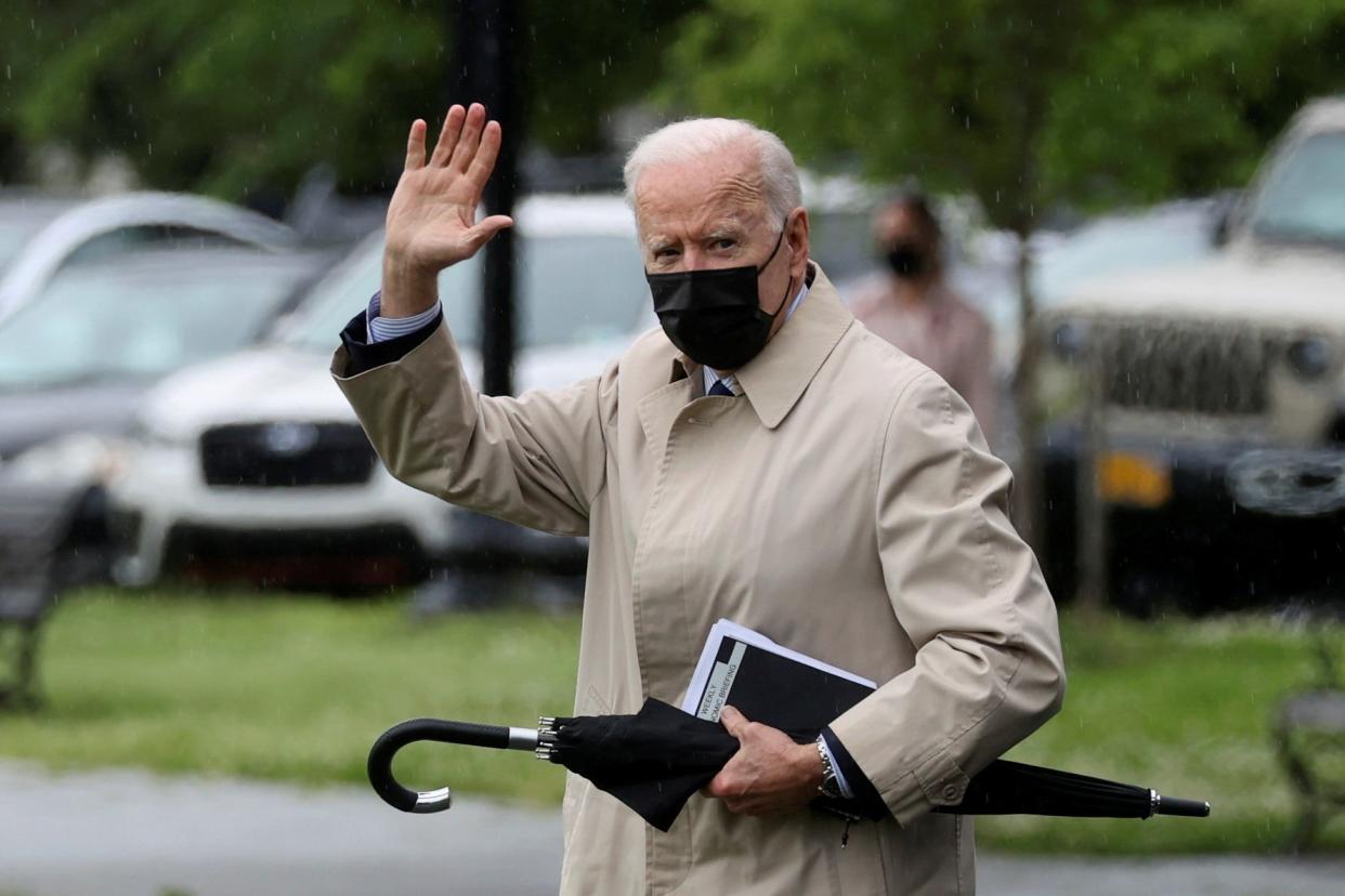 Joe Biden waves before boarding the Marine One helicopter for a planned weekend at Camp David (REUTERS)