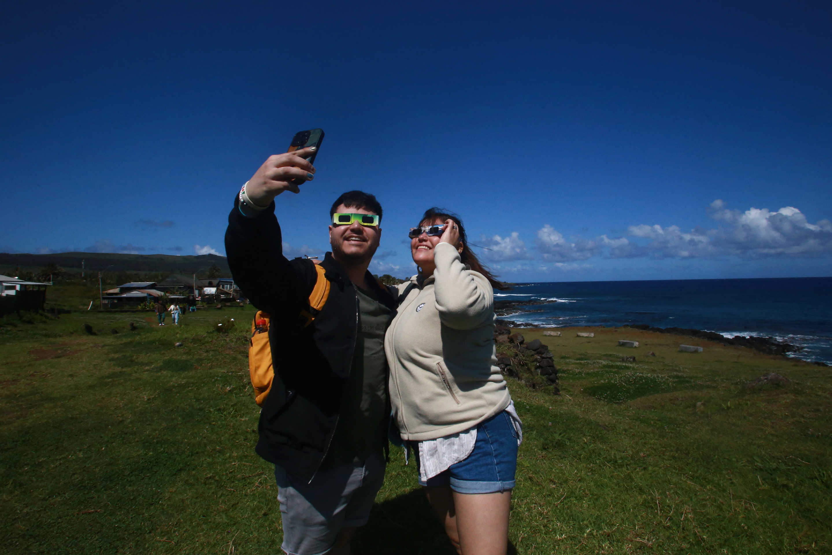 Ein paar Touristen machen ein Selfie, während sie sich darauf vorbereiten, die ringförmige Sonnenfinsternis am Mittwoch auf der Pazifikinsel Pascua in Chile zu beobachten.