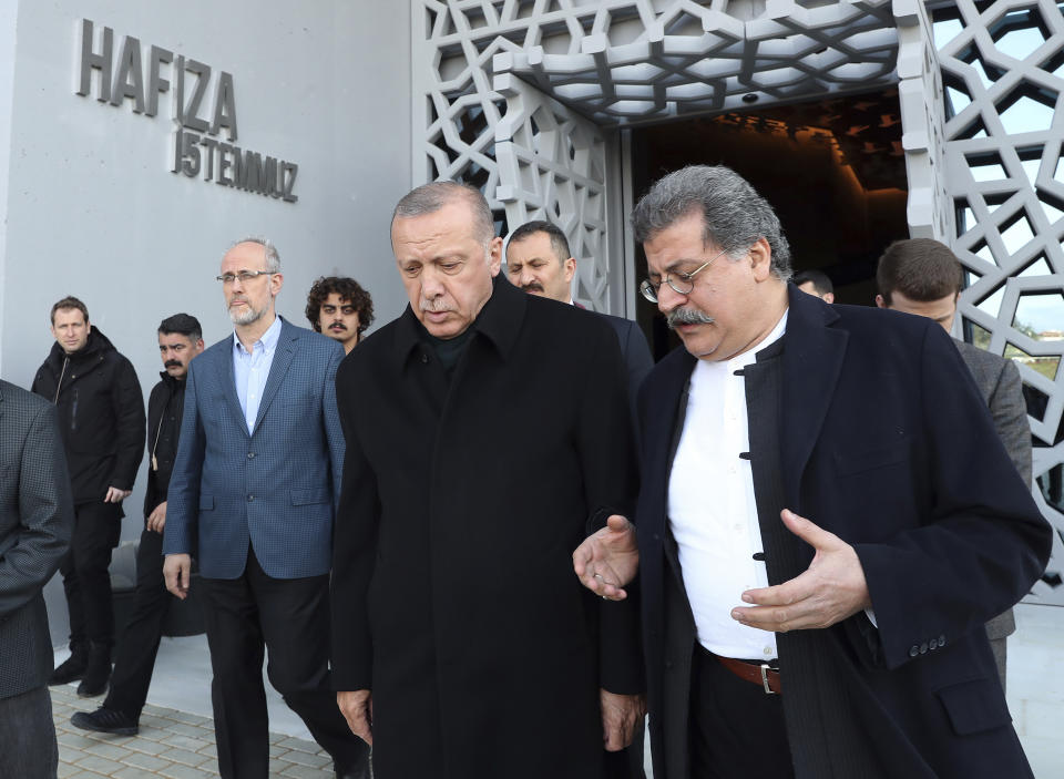 Turkey's President Recep Tayyip Erdogan, center, in a first public appearance after Sunday elections in Istanbul, Thursday, April 4, 2019, listens as he visits an uncompleted museum dedicated to the July 15, 2015 coup attempt. Erdogan's ruling party is appealing the results of the local elections in Istanbul, where the opposition has a razor-thin lead. (Presidential Press Service via AP, Pool)