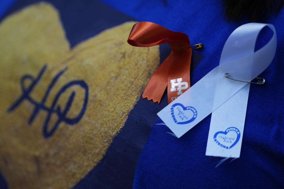 Lonni Serlin wears ribbons in honor of the victims and those injured last year Fourth of July mass shooting as she attends remembrance ceremony in Highland Park, Ill., Tuesday, July 4, 2023. One year after a shooter took seven lives at the city's annual parade, community members are planning to honor the victims and reclaim the space to move forward. (AP Photo/Nam Y. Huh)