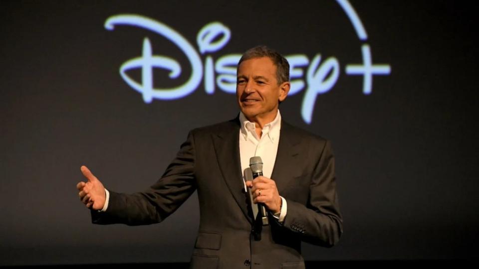 Bob Iger in front of a Disney+ logo