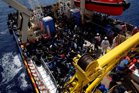 Migrants rest on the deck of the Migrant Offshore Aid Station (MOAS) ship Topaz Responder after being rescued around 20 nautical miles off the coast of Libya, June 23, 2016. REUTERS/Darrin Zammit Lupi