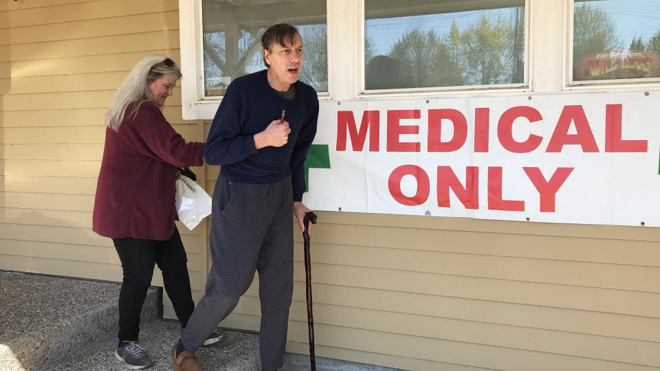 ADVANCE FOR PUBLICATION ON TUESDAY, JUNE 11, AND THEREAFTER - In this April 26, 2019, photo, medical marijuana cardholder Scott Donnelly, assisted by his wife and licensed caregiver, Vicki Poppen, leaves Western Oregon Dispensary in Sherwood, Ore., after buying medical marijuana to treat muscle spasms caused by his multiple sclerosis. Donnelly visits the medical-only dispensary once a week and relies on it for the cannabis that eases his tremors long enough that he can fall asleep. The dispensary is one of two medical-only shops left in Oregon. (AP Photo/Gillian Flaccus)