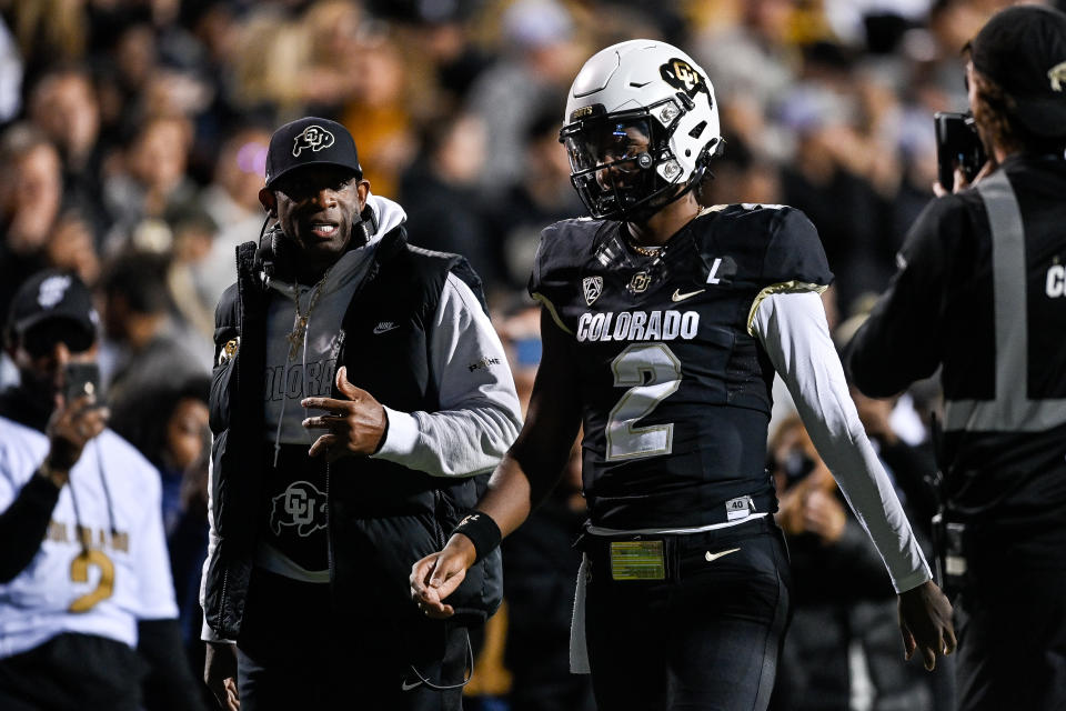 BOULDER, CO - NOVEMBER 4:  Head coach Deion Sanders of the Colorado Buffaloes (L) has a word with Shedeur Sanders #2 before his first offensive drive in the first half of a game against the Oregon State Beavers at Folsom Field on November 4, 2023 in Boulder, Colorado. (Photo by Dustin Bradford/Getty Images)