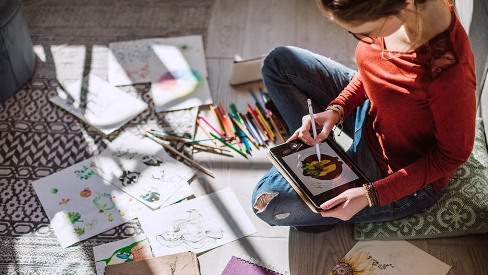 A young woman illustrator works using one of the best tablets with a stylus pen