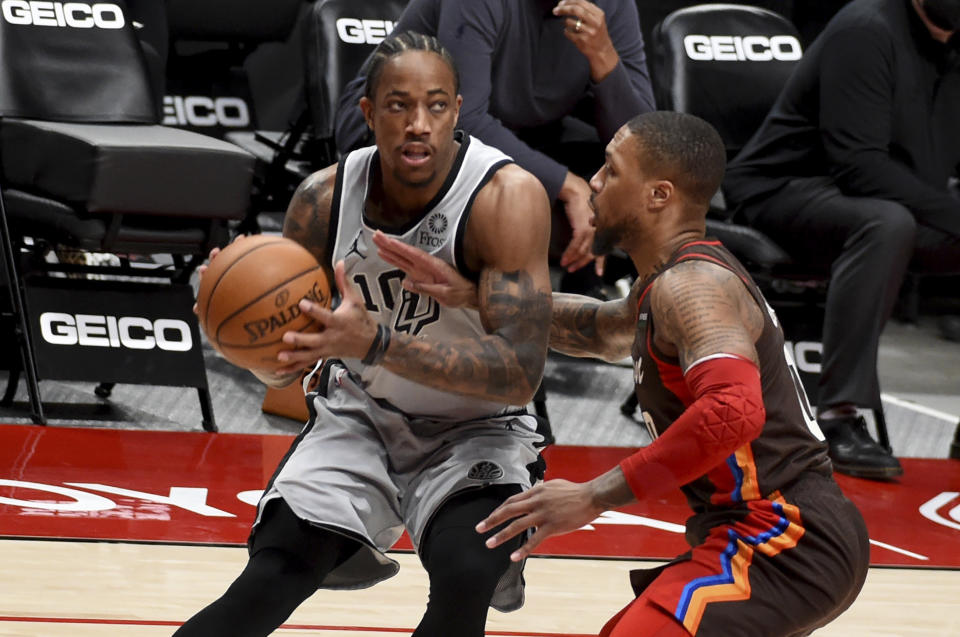 San Antonio Spurs forward DeMar DeRozan, left, is defended by Portland Trail Blazers guard Damian Lillard during the first half of an NBA basketball game in Portland, Ore., Saturday, May 8, 2021. (AP Photo/Steve Dykes)