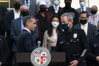 Joined by business owners and community leaders, Los Angeles Mayor Eric Garcetti, left, and Police Chief Michel Moore shake hands during a news conference outside the Los Angeles Police Headquarters in Los Angeles, Thursday, Dec. 2, 2021. Authorities in Los Angeles on Thursday announced arrests in recent smash-and-grab thefts at stores, part of a rash of organized retail crime in California. (AP Photo/Jae C. Hong)