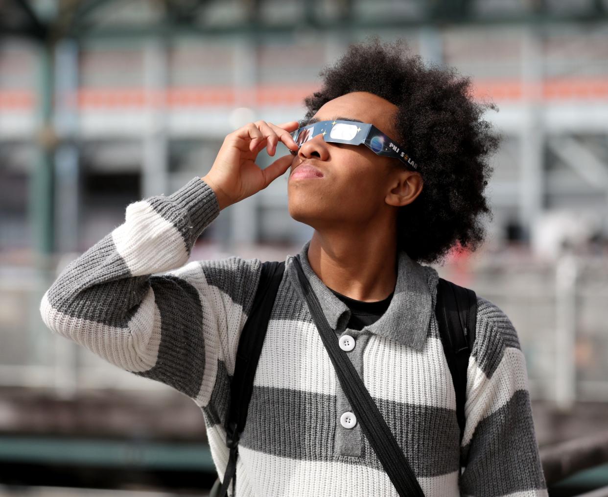 Sean-Daniel Boone views the solar eclipse from the Yonkers New York waterfront, April 8, 2024.